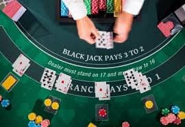 Live casino dealer at blackjack table with multiple camera angles